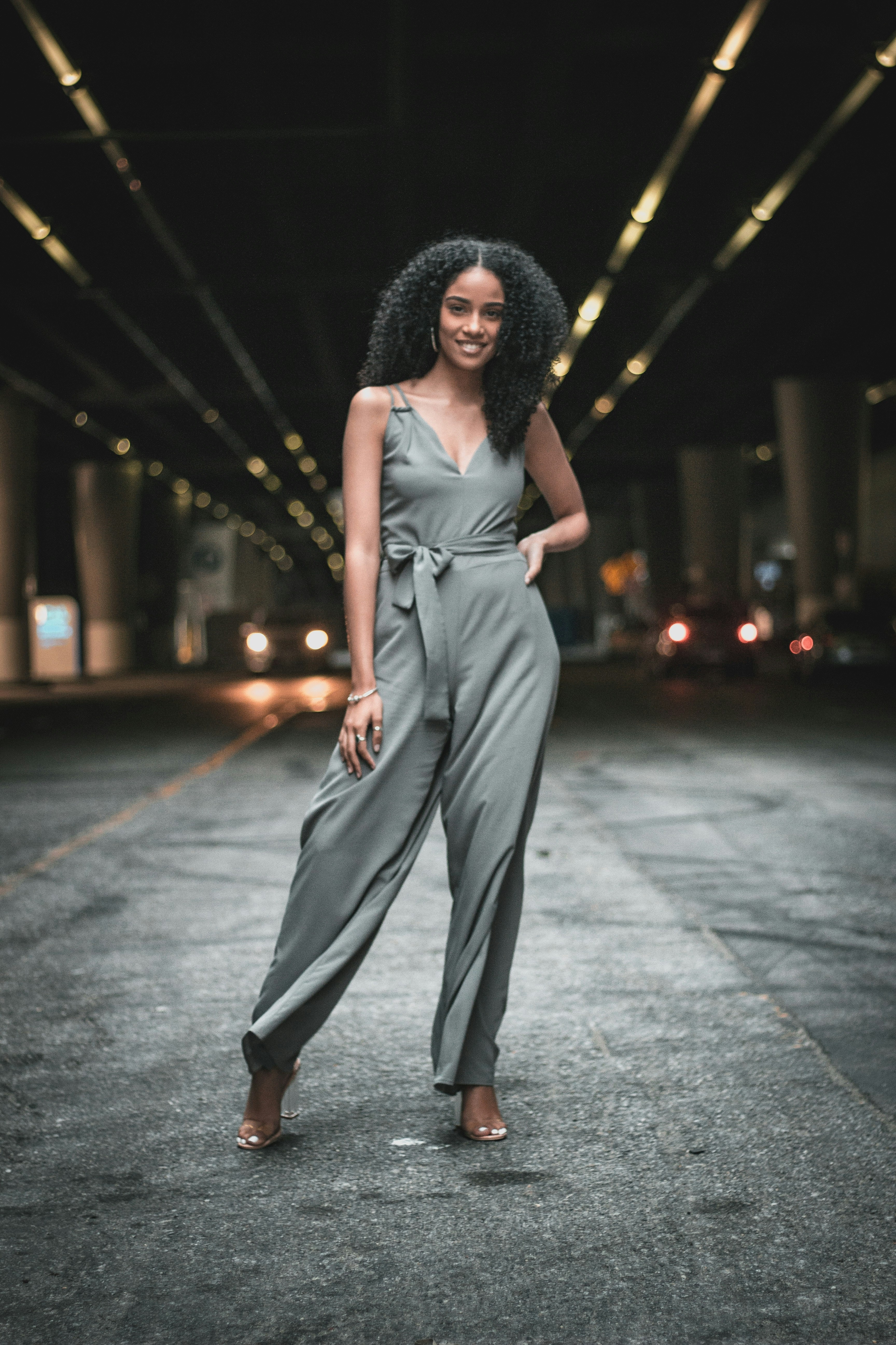 Before: supplied real woman model in the original grey sleeveless wrap jumpsuit and heels
